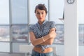 Young attractive woman standing, holding arms crossed, wearing blue denim pants, having flat naked stomach with piercing Royalty Free Stock Photo