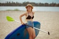 Young attractive woman standing next to paddle board, SUP. Active life, sport, leisure activity concept Royalty Free Stock Photo