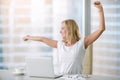 Young attractive woman stretching at office desk