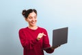 Young attractive woman student with funny face holding a laptop and pointing into it applaying for university or college enrolment Royalty Free Stock Photo