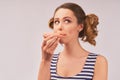 Happy girl holds donut and chews mouth full Royalty Free Stock Photo