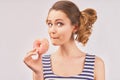 Happy girl holds donut and chews mouth full Royalty Free Stock Photo