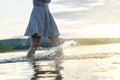 Young attractive woman in sunset. Water splashing when walking. Royalty Free Stock Photo