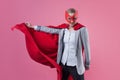 Young attractive woman superhero. Girl in a business suit and a mask with red cloak of hero. Royalty Free Stock Photo