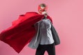 Young attractive woman superhero. Girl in a business suit and a mask with red cloak of hero. Royalty Free Stock Photo