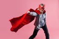 Young attractive woman superhero. Girl in a business suit and a mask with red cloak of hero. Royalty Free Stock Photo