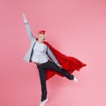 Young attractive woman superhero. Girl in a business suit and a mask with red cloak of hero. Royalty Free Stock Photo