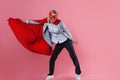 Young attractive woman superhero. Girl in a business suit and a mask with red cloak of hero. Royalty Free Stock Photo