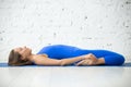 Young attractive woman in Supta Virasana pose, white studio back Royalty Free Stock Photo