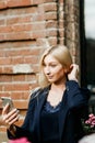 A young attractive woman takes a picture of herself on her smartphone, sitting on a street bench during the lunch break Royalty Free Stock Photo