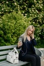 A young attractive woman takes a picture of herself on her smartphone, sitting on a street bench during the lunch break Royalty Free Stock Photo