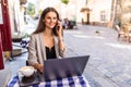 Young attractive woman talking on mobile phone and smiling while sitting alone in coffee shop during free time and working on Royalty Free Stock Photo