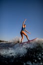 Young attractive woman vigorously rides the wave on surf style wakeboard Royalty Free Stock Photo