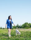 Young attractive woman walking her dog in the park in summer day Royalty Free Stock Photo