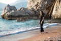 Young attractive woman walking on a sunny beach at shore. Traveler and blogger Royalty Free Stock Photo