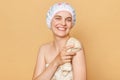 Young attractive woman wearing bath towel and shower cap happy face smiling looking at camera washing her body talking shower Royalty Free Stock Photo