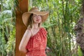 Young attractive woman wearing a cute summer dress, an oversized straw hat with wide brims, smiling and looking at the camera Royalty Free Stock Photo