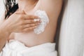 Young attractive woman in white towel applying shaving cream on armpit for depilation in home bathroom. Skin care. Hair Removal Royalty Free Stock Photo