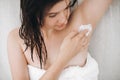 Young attractive woman in white towel applying shaving cream on armpit for depilation in home bathroom. Skin care. Hair Removal Royalty Free Stock Photo