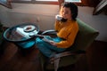 Young Attractive Woman in Yellow Cozy Sweater Drinking Hot Tea and Reading Magazine at Attic Mansard Royalty Free Stock Photo