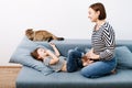 Young attractive woman with her little preschooler daughter having fun at home on couch