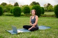 Young attractive women sitting at yoga class on fitness mat while watching fitness videos using laptop during video Royalty Free Stock Photo