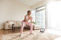 Woman making deep squats in living room at home