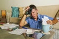 Young attractive worried and stressed man at home calculating month tax expenses with calculator accounting payments doing bank pa Royalty Free Stock Photo