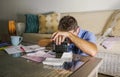 Young attractive worried and stressed man at home calculating month tax expenses with calculator accounting payments doing bank pa Royalty Free Stock Photo