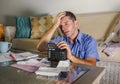 Young attractive worried and stressed man at home calculating month tax expenses with calculator accounting payments doing bank pa Royalty Free Stock Photo