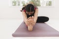 Young attractive yogi woman practicing yoga concept, sitting in Janu Sirsasana exercise, Head to Knee Forward Bend pose, working Royalty Free Stock Photo