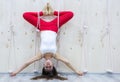 Young attractive yogi woman practicing yoga concept, standing in variation of Pincha Mayurasana exercise, handstand pose, working Royalty Free Stock Photo