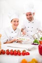 Young attractives professionals chefs cooking together Royalty Free Stock Photo