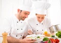 Young attractives professionals chefs cooking together Royalty Free Stock Photo