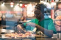 Young authentic black woman sitting with phone in city coffee shop at night