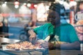 Young authentic black woman sitting with phone in city coffee shop at night