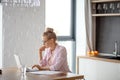 Young awesome female freelancer working on notebook indoors