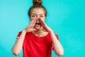 Young awesome girl with hairbun calling out for help Royalty Free Stock Photo