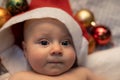 Young Baby In A Cot With Christmas Baubles