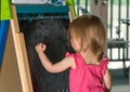 Young baby girl drawing at blackboard Royalty Free Stock Photo