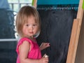 Young baby girl drawing at blackboard Royalty Free Stock Photo