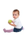 Young baby girl eating fresh green apple