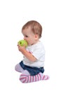 Young baby girl eating fresh green apple