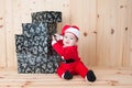 Young baby wearing a santa claus suit and hat in christmas in a barn Royalty Free Stock Photo