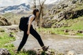 Young backpacker hiker woman enjoying relaxing mountain hike.Active hiking trip vacation.Walking by the mountain stream.Climber