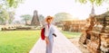 Young backpacker Tourist woman with a modern mirrorless camera enjoying walking at ancient ruins during her Asian vacation,