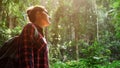 Young backpacker woman in checkered shirt walks in breathtaking lush tropical forest
