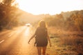 Young backpacking adventurous woman hitchhiking on the road.Ready for adventure of life.Travel lifestyle.Low budget traveling.Adve Royalty Free Stock Photo