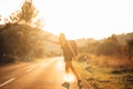 Young backpacking adventurous woman hitchhiking on the road.Ready for adventure of life.Travel lifestyle.Low budget traveling.Adve Royalty Free Stock Photo