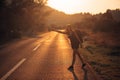 Young backpacking adventurous woman hitchhiking on the road.Ready for adventure of life.Travel lifestyle.Low budget traveling.Adve Royalty Free Stock Photo